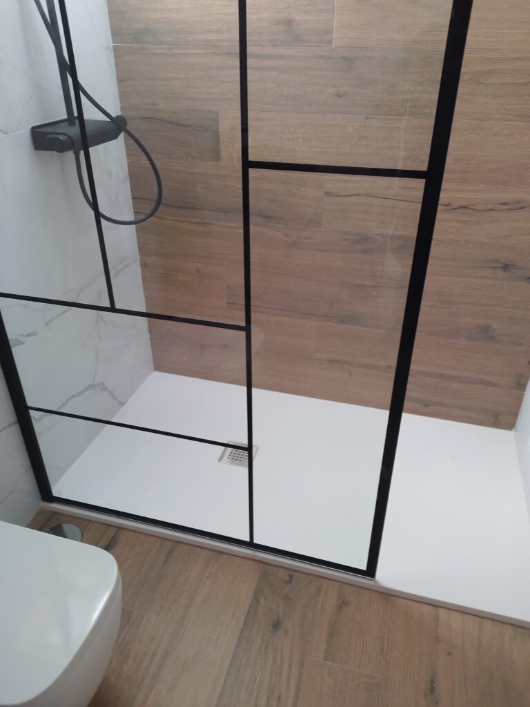 Reforma de baño con ducha, mampara y acabado efecto madera
