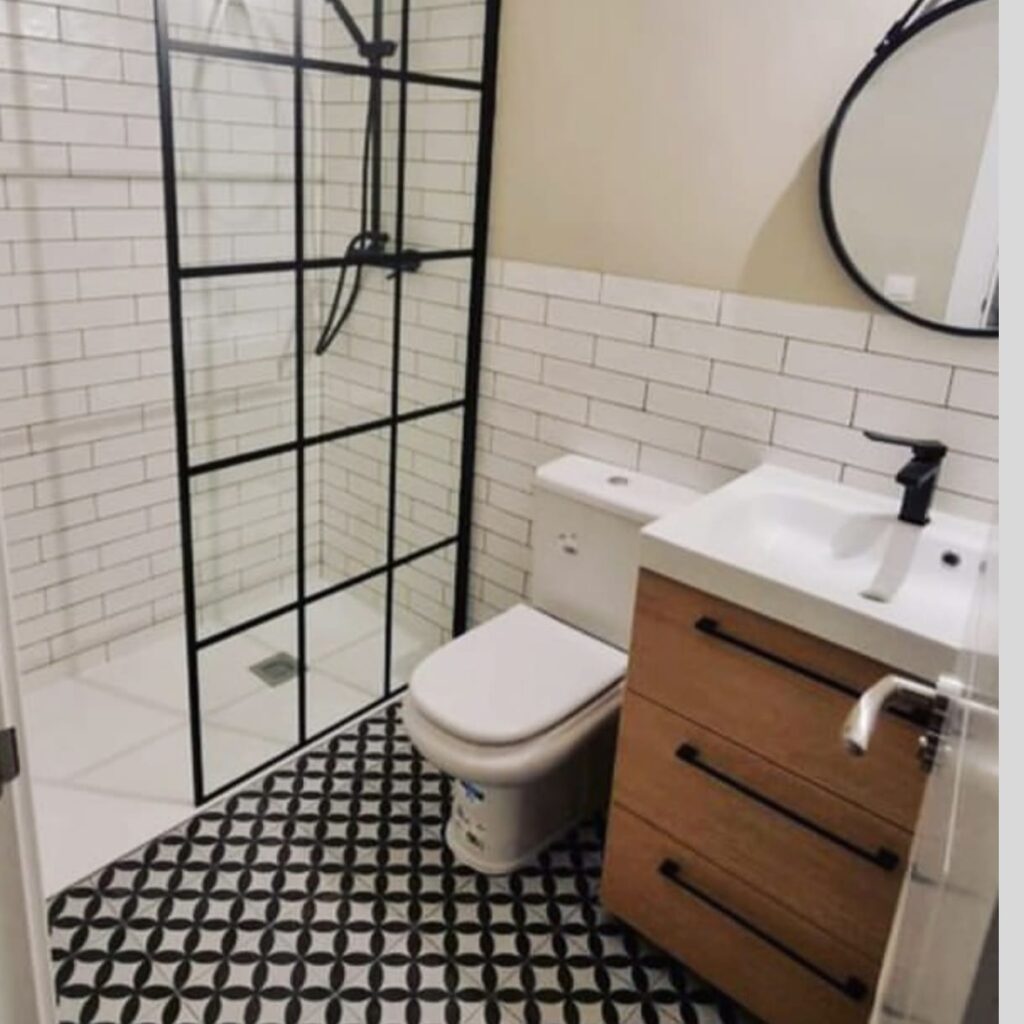 Reforma de baño moderno con azulejos blancos y mampara