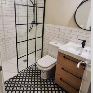 Reforma de baño moderno con azulejos blancos y mampara
