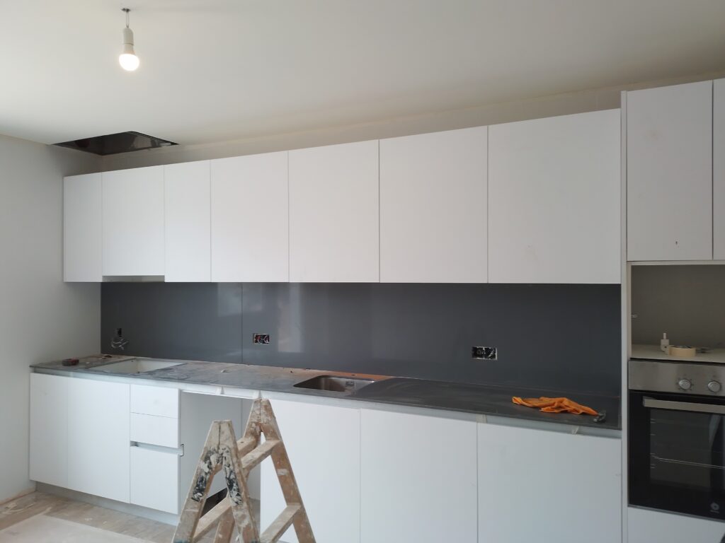 Reforma de cocina moderna con muebles blancos y encimera oscura