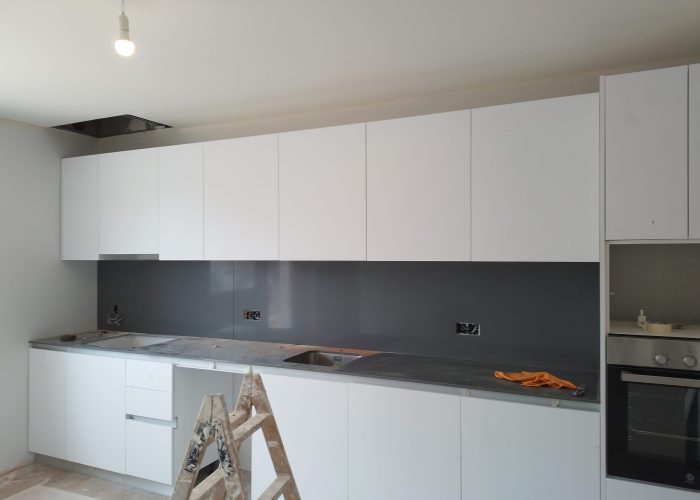 Reforma de cocina moderna con muebles blancos y encimera oscura